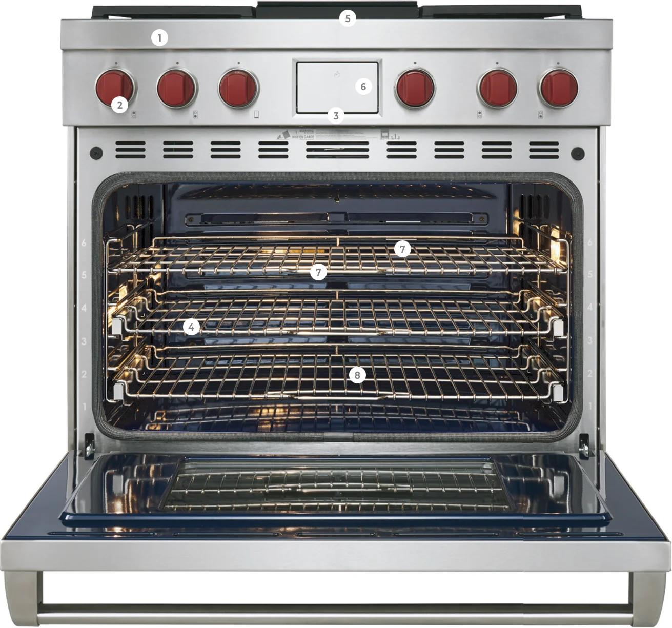 Open stainless steel oven with three wire racks and red control knobs.
